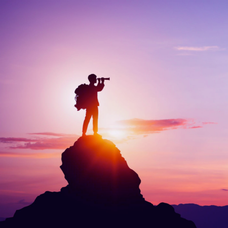 A hiker standing at the top of a mountain.